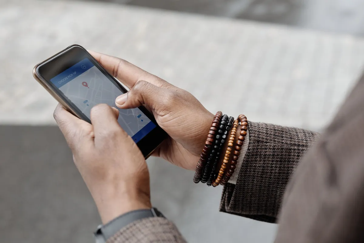 Hands holding a phone with a map pin, searching for a nearby business