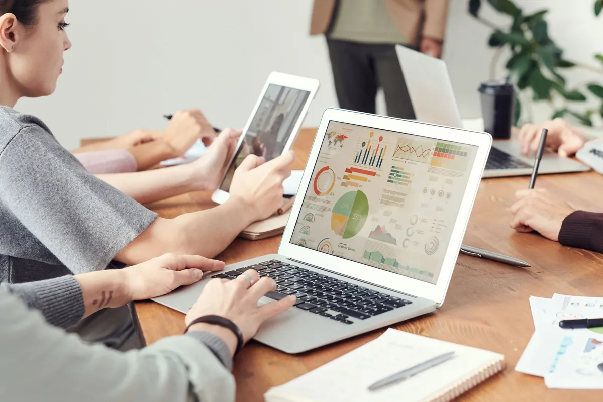 SEO virtual assistant reviewing an analytics report on a laptop during a team meeting