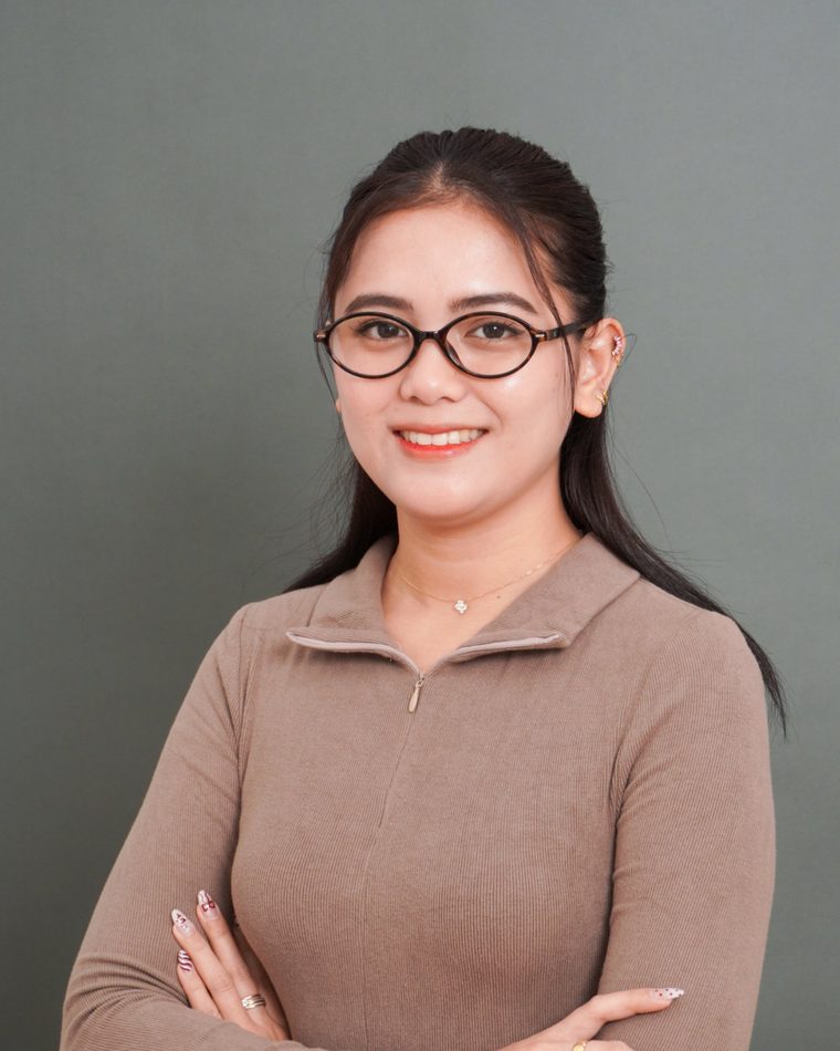 Maria Belinda, executive assistant for marketing, smiling with arms crossed